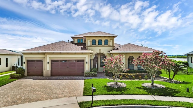 15344 Johns Lake Pointe Blvd, Winter Garden, FL 34787 - mediterranean / spanish-style home featuring stucco siding, decorative driveway, a garage, a front yard, and roof with shingles