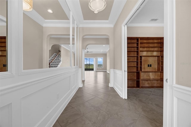 15344 Johns Lake Pointe Blvd, Winter Garden, FL 34787 - hallway featuring a wainscoted wall, ornamental molding, arched walkways, a decorative wall, and tile patterned floors