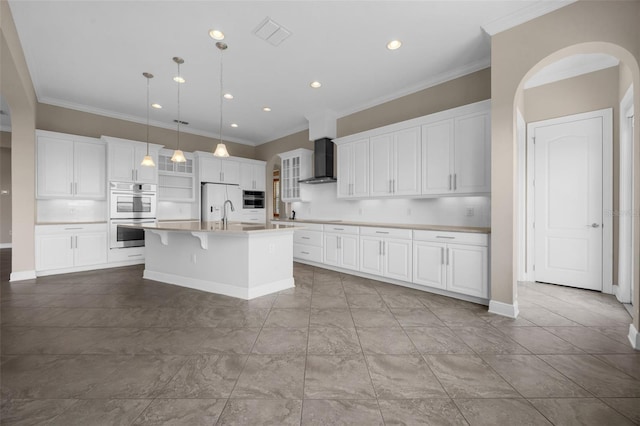15344 Johns Lake Pointe Blvd, Winter Garden, FL 34787 - kitchen with stainless steel double oven, wall chimney range hood, a center island with sink, ornamental molding, and light countertops