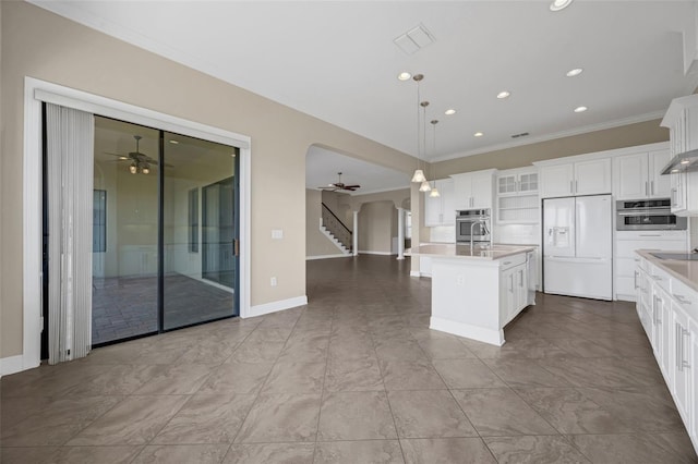 15344 Johns Lake Pointe Blvd, Winter Garden, FL 34787 - kitchen featuring white fridge with ice dispenser, ceiling fan, stainless steel oven, ornamental molding, and an island with sink