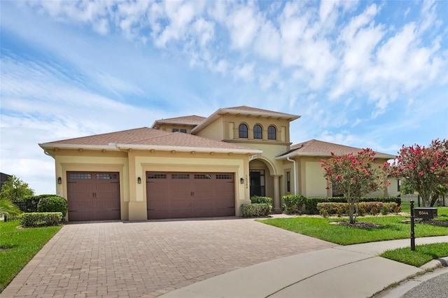 15344 Johns Lake Pointe Blvd, Winter Garden, FL 34787 - mediterranean / spanish house with a garage, stucco siding, decorative driveway, and a front yard