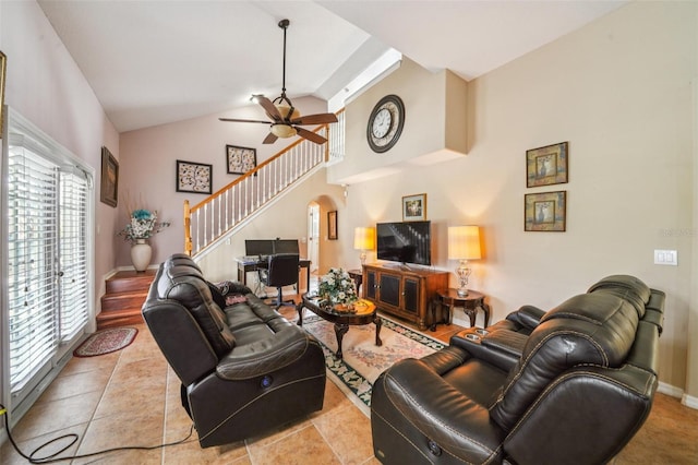 742 Seneca Trl, Saint Cloud, FL 34772 - living room with stairway, arched walkways, a ceiling fan, baseboards, and high vaulted ceiling