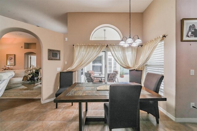 742 Seneca Trl, Saint Cloud, FL 34772 - dining area with arched walkways, a chandelier, tile patterned flooring, and baseboards