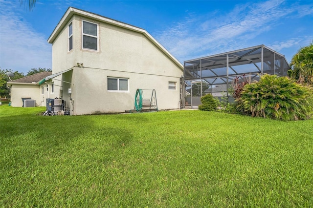 742 Seneca Trl, Saint Cloud, FL 34772 - rear view of house featuring stucco siding, cooling unit, a lawn, and glass enclosure