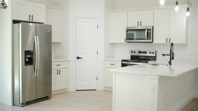 2498 W Magenta Dr, Citrus Springs, FL 34434 - kitchen featuring stainless steel appliances, light wood-type flooring, a peninsula, and white cabinets