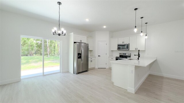 2498 W Magenta Dr, Citrus Springs, FL 34434 - kitchen featuring appliances with stainless steel finishes, light wood-style floors, a chandelier, a peninsula, and white cabinets