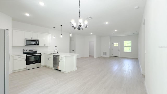 2498 W Magenta Dr, Citrus Springs, FL 34434 - kitchen with stainless steel appliances, a peninsula, open floor plan, a chandelier, and light wood-style flooring