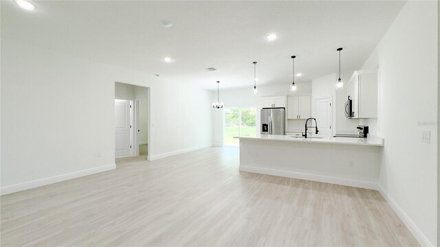 2498 W Magenta Dr, Citrus Springs, FL 34434 - kitchen with stainless steel appliances, light wood-type flooring, a peninsula, white cabinetry, and light countertops