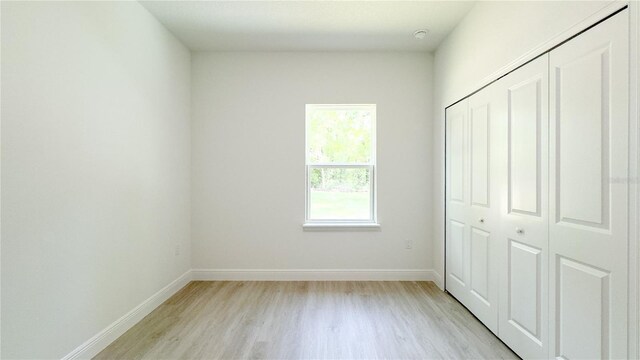 2498 W Magenta Dr, Citrus Springs, FL 34434 - unfurnished bedroom featuring light wood finished floors and a closet