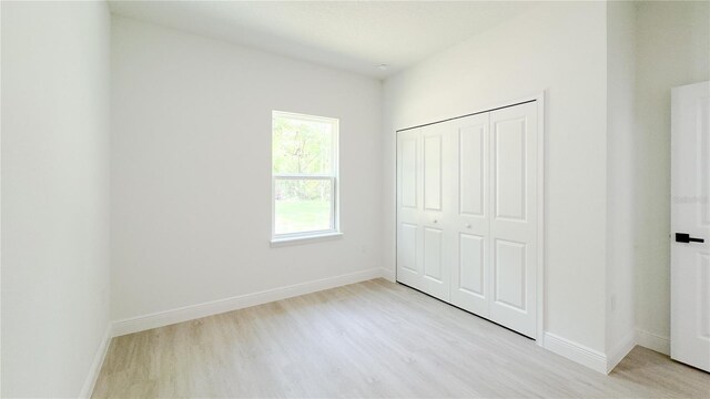 2498 W Magenta Dr, Citrus Springs, FL 34434 - unfurnished bedroom featuring light wood finished floors and a closet