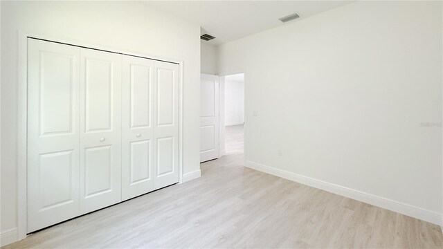 2498 W Magenta Dr, Citrus Springs, FL 34434 - unfurnished bedroom with light wood-type flooring and a closet