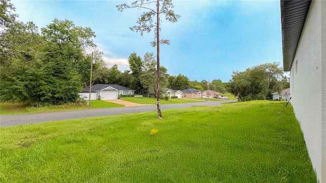 2498 W Magenta Dr, Citrus Springs, FL 34434 - view of grassy yard featuring a detached garage and a residential view
