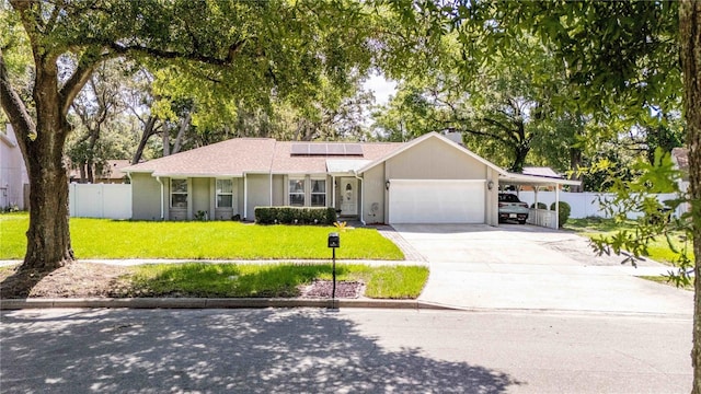 5177 Chesapeake Ave, Orlando, FL 32808 - ranch-style house featuring a garage, driveway, roof mounted solar panels, and a carport