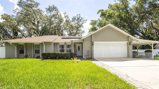 5177 Chesapeake Ave, Orlando, FL 32808 - view of front of home featuring stucco siding, a garage, solar panels, driveway, and a shingled roof