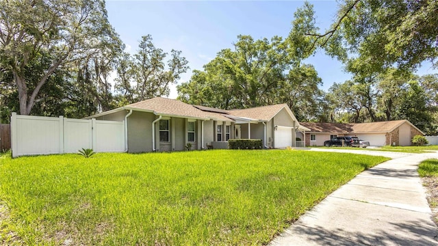 5177 Chesapeake Ave, Orlando, FL 32808 - ranch-style home featuring an attached garage, solar panels, stucco siding, and concrete driveway