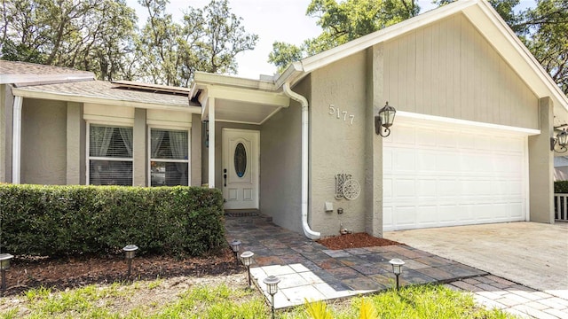 5177 Chesapeake Ave, Orlando, FL 32808 - view of front facade featuring a garage, stucco siding, driveway, and roof with shingles