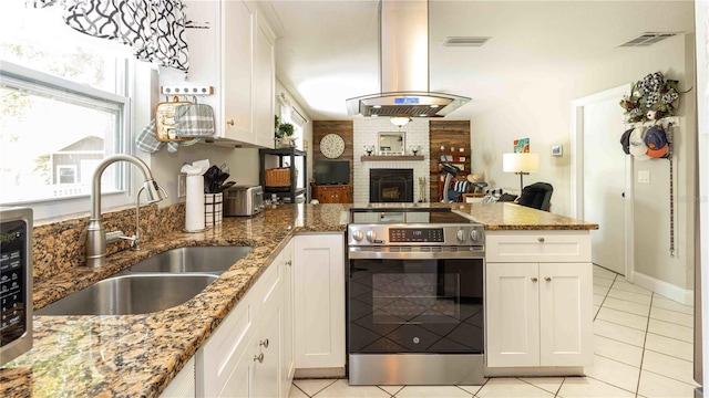 5177 Chesapeake Ave, Orlando, FL 32808 - kitchen featuring stainless steel range with electric stovetop, island exhaust hood, light tile patterned flooring, and a peninsula