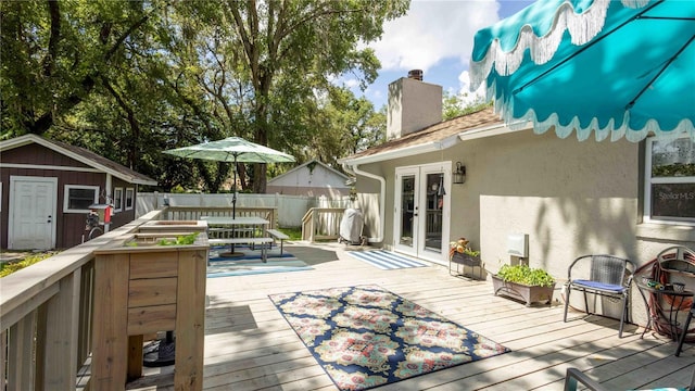 5177 Chesapeake Ave, Orlando, FL 32808 - deck with french doors, outdoor dining area, and a storage unit