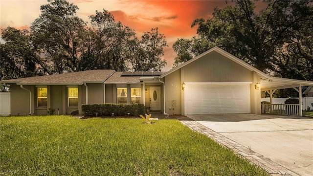 5177 Chesapeake Ave, Orlando, FL 32808 - ranch-style house featuring driveway, a garage, roof mounted solar panels, and stucco siding