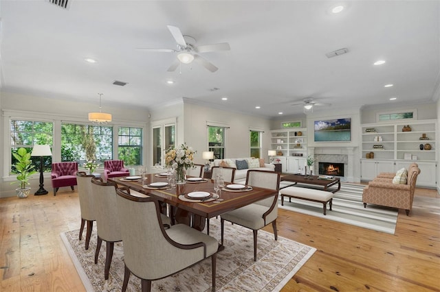 408 W Pearl St, Minneola, FL 34715 - dining area featuring ceiling fan, crown molding, light wood-type flooring, recessed lighting, and a lit fireplace
