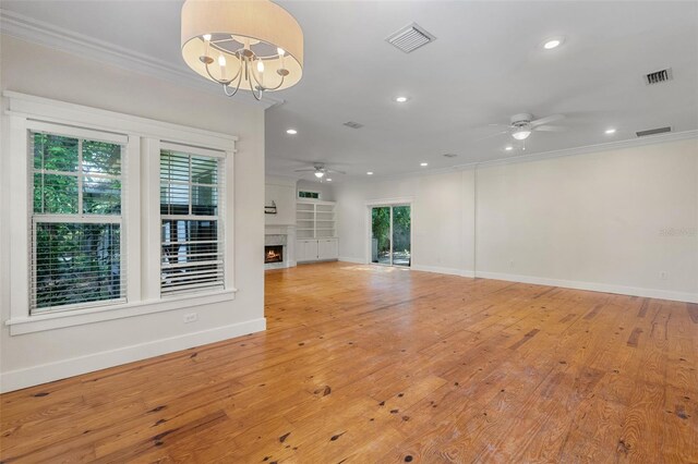 408 W Pearl St, Minneola, FL 34715 - unfurnished living room with ceiling fan, ornamental molding, recessed lighting, a lit fireplace, and a chandelier