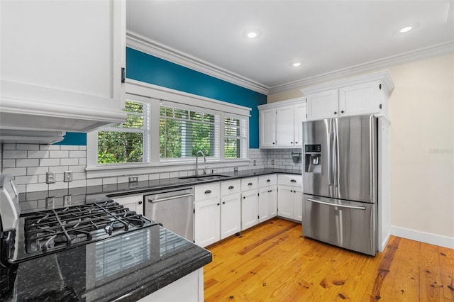 408 W Pearl St, Minneola, FL 34715 - kitchen featuring stainless steel appliances, crown molding, white cabinetry, tasteful backsplash, and light wood-type flooring