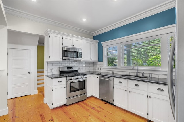 408 W Pearl St, Minneola, FL 34715 - kitchen featuring appliances with stainless steel finishes, ornamental molding, white cabinetry, backsplash, and light wood-style floors