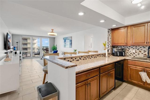 2947 S Atlantic Ave Unit 601, Daytona Beach, FL 32118 - kitchen with decorative backsplash, light tile patterned floors, a peninsula, light stone counters, and recessed lighting