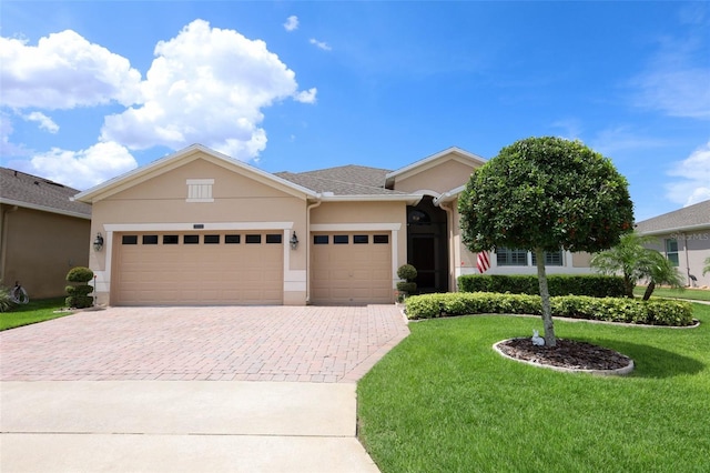 3574 La Jolla Dr, Clermont, FL 34711 - ranch-style home featuring stucco siding, decorative driveway, a garage, and a front yard