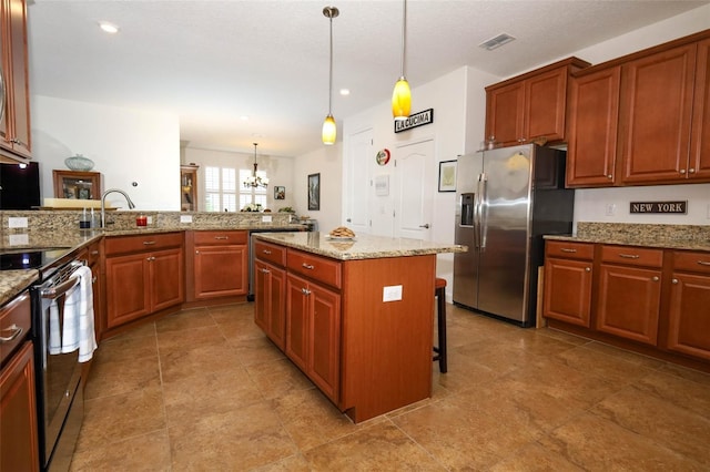 3574 La Jolla Dr, Clermont, FL 34711 - kitchen featuring appliances with stainless steel finishes, a breakfast bar area, a chandelier, decorative light fixtures, and light stone countertops