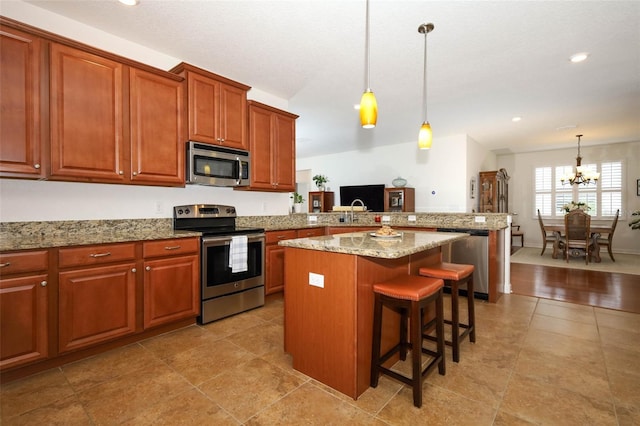3574 La Jolla Dr, Clermont, FL 34711 - kitchen with appliances with stainless steel finishes, a peninsula, a chandelier, a breakfast bar, and hanging light fixtures