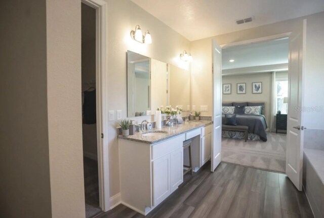 351 S Sunset Ave, Mascotte, FL 34753 - ensuite bathroom with wood finished floors, double vanity, and a tub to relax in