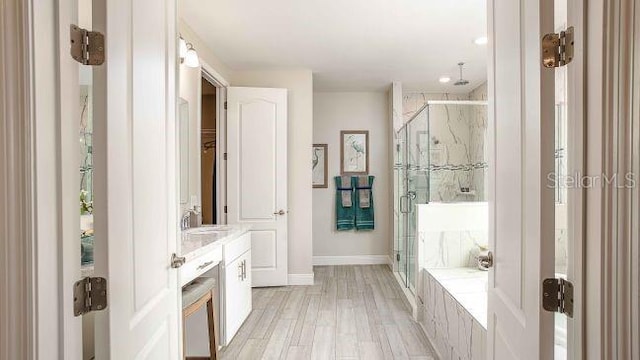 351 S Sunset Ave, Mascotte, FL 34753 - full bath with a marble finish shower, vanity, a garden tub, baseboards, and recessed lighting