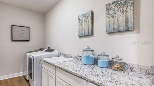 351 S Sunset Ave, Mascotte, FL 34753 - washroom featuring washer and clothes dryer, cabinet space, wood finished floors, and baseboards