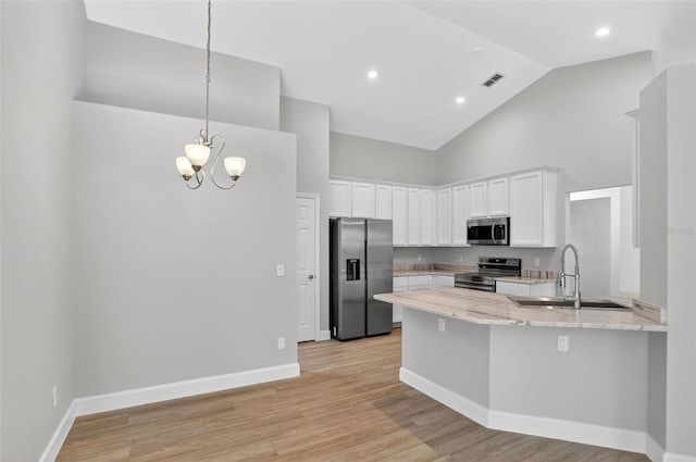 632 Bridge Creek Blvd, Ocoee, FL 34761 - kitchen featuring appliances with stainless steel finishes, high vaulted ceiling, a peninsula, white cabinetry, and light stone counters