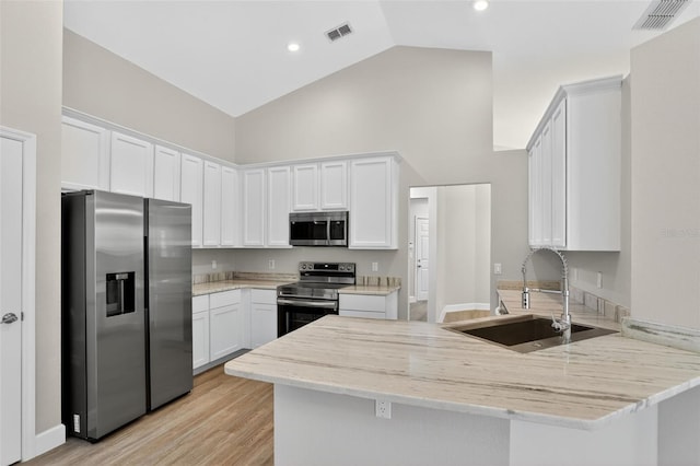 632 Bridge Creek Blvd, Ocoee, FL 34761 - kitchen featuring appliances with stainless steel finishes, a peninsula, high vaulted ceiling, white cabinetry, and light stone counters