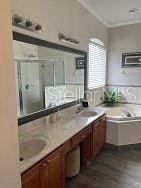 160 Calabay Parc Blvd, Davenport, FL 33897 - bathroom featuring a stall shower, double vanity, wood finished floors, a bathtub, and ornamental molding