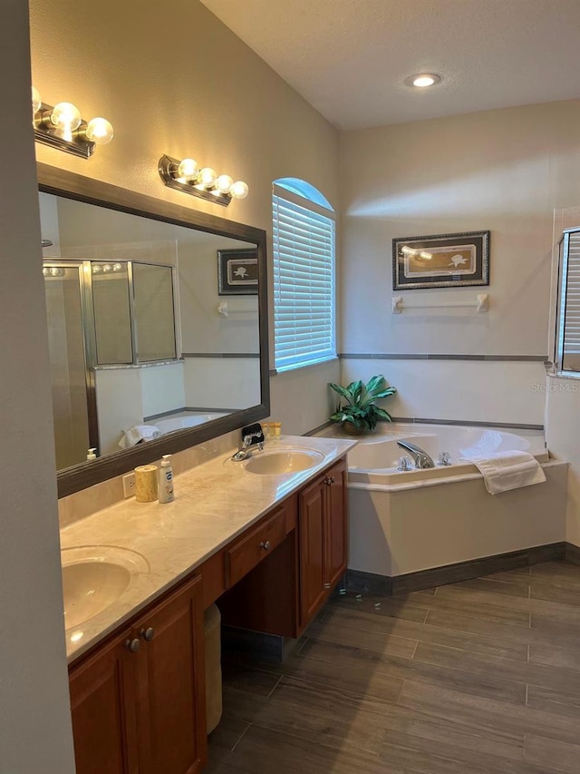 160 Calabay Parc Blvd, Davenport, FL 33897 - full bathroom featuring a bath, double vanity, a stall shower, and wood finished floors