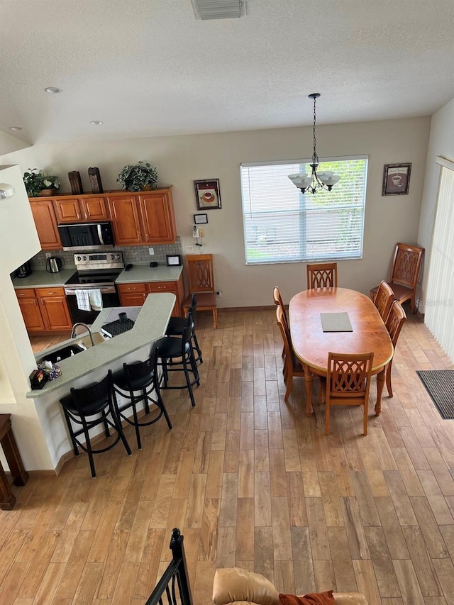 160 Calabay Parc Blvd, Davenport, FL 33897 - dining room featuring light wood-style flooring, a chandelier, and a textured ceiling