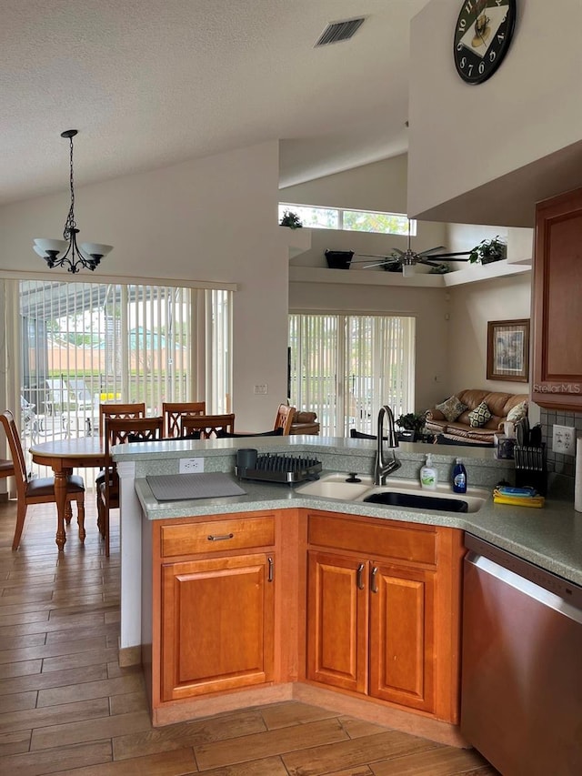 160 Calabay Parc Blvd, Davenport, FL 33897 - kitchen with stainless steel dishwasher, a chandelier, light wood-style flooring, brown cabinetry, and decorative light fixtures
