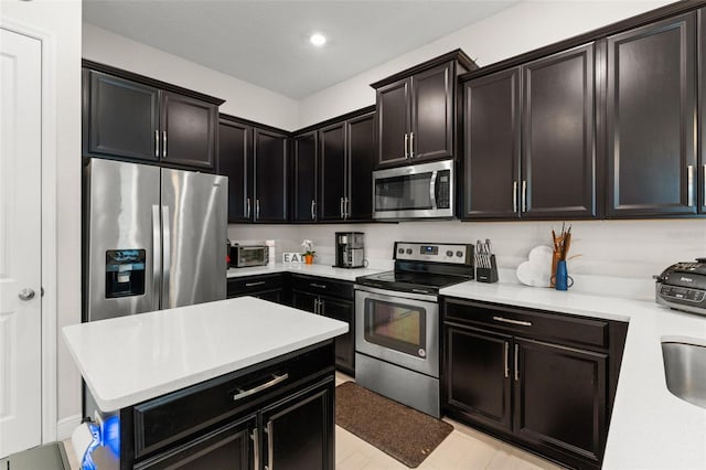 1787 White Feather Loop, Oakland, FL 34787 - kitchen with stainless steel appliances, light countertops, recessed lighting, dark cabinets, and a kitchen island
