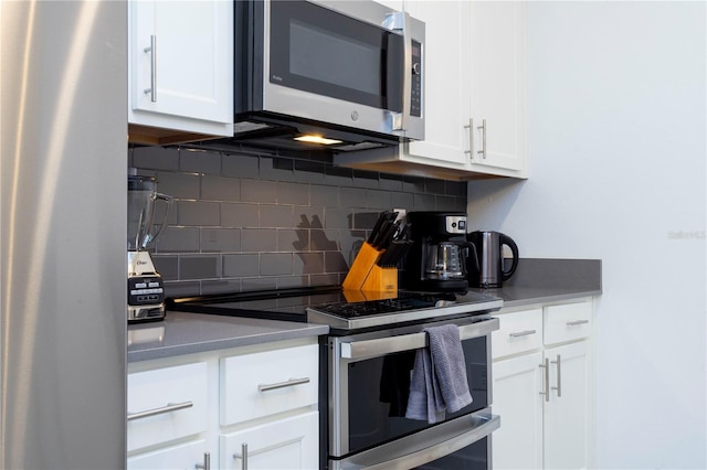 1070 Splash Shot Pl, Davenport, FL 33896 - kitchen featuring appliances with stainless steel finishes, tasteful backsplash, and white cabinetry