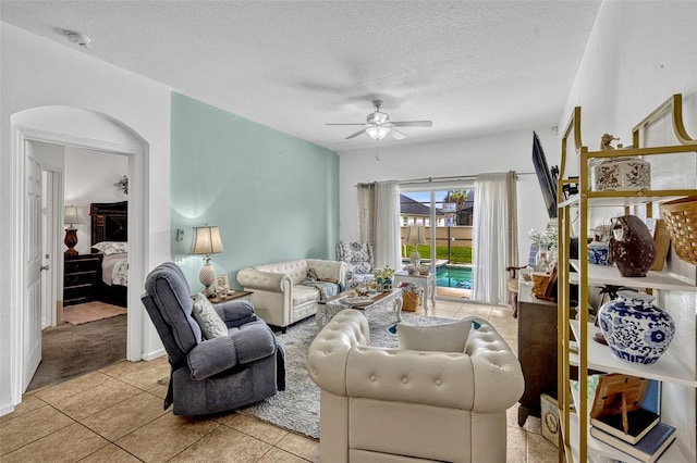 8152 Fan Palm Way, Kissimmee, FL 34747 - living area with a ceiling fan, light tile patterned floors, a textured ceiling, and light carpet