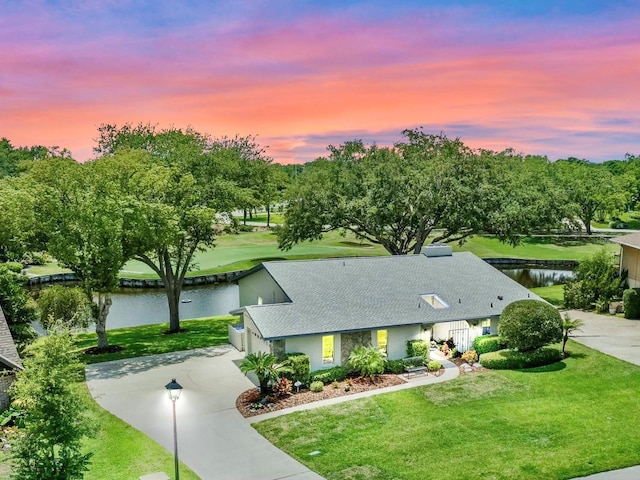 6836 Bittersweet Ln, Orlando, FL 32819 - view of front of house featuring driveway, a water view, and a yard