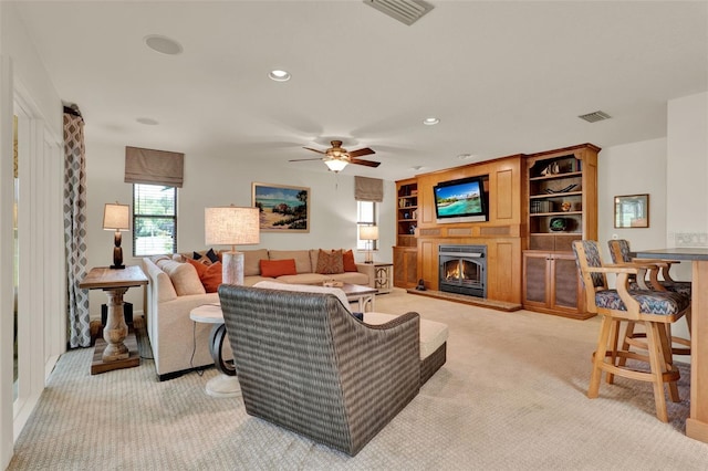 6836 Bittersweet Ln, Orlando, FL 32819 - living room with a warm lit fireplace, light carpet, a ceiling fan, and recessed lighting
