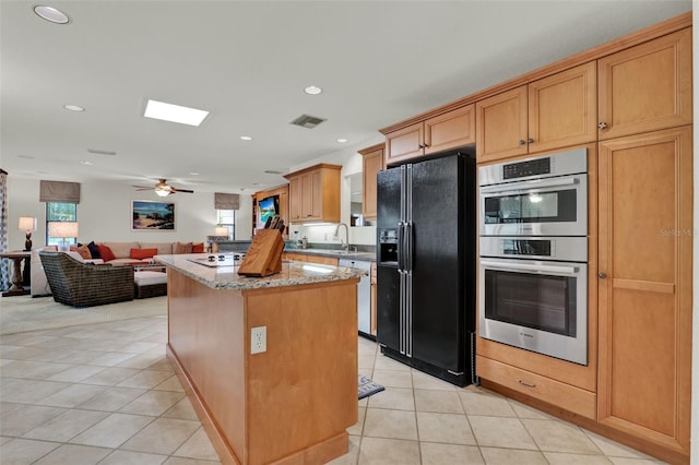 6836 Bittersweet Ln, Orlando, FL 32819 - kitchen featuring black refrigerator with ice dispenser, double oven, plenty of natural light, light tile patterned flooring, and recessed lighting