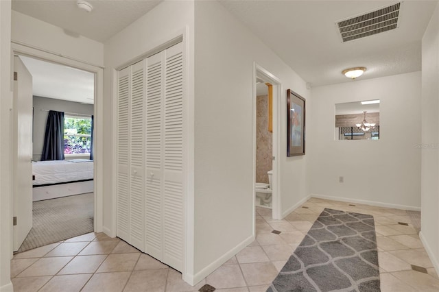 6836 Bittersweet Ln, Orlando, FL 32819 - hallway featuring light tile patterned flooring and a chandelier