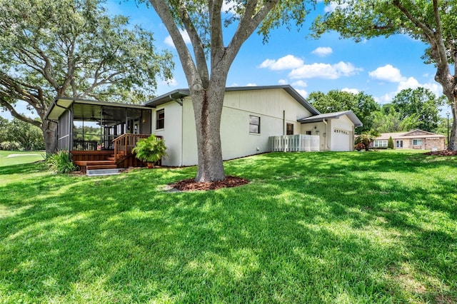 6836 Bittersweet Ln, Orlando, FL 32819 - back of house with a sunroom, an attached garage, a lawn, and stucco siding