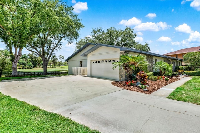6836 Bittersweet Ln, Orlando, FL 32819 - view of property exterior featuring a garage, driveway, stone siding, and stucco siding