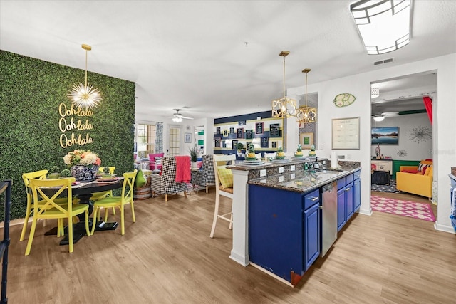 5012 Shoreway Loop Unit 10107, Orlando, FL 32819 - kitchen featuring blue cabinets, light wood-type flooring, dishwasher, ceiling fan, and a kitchen bar